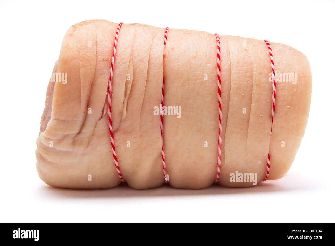 A joint of rolled belly pork trussed up with stripey string. Stock Photo