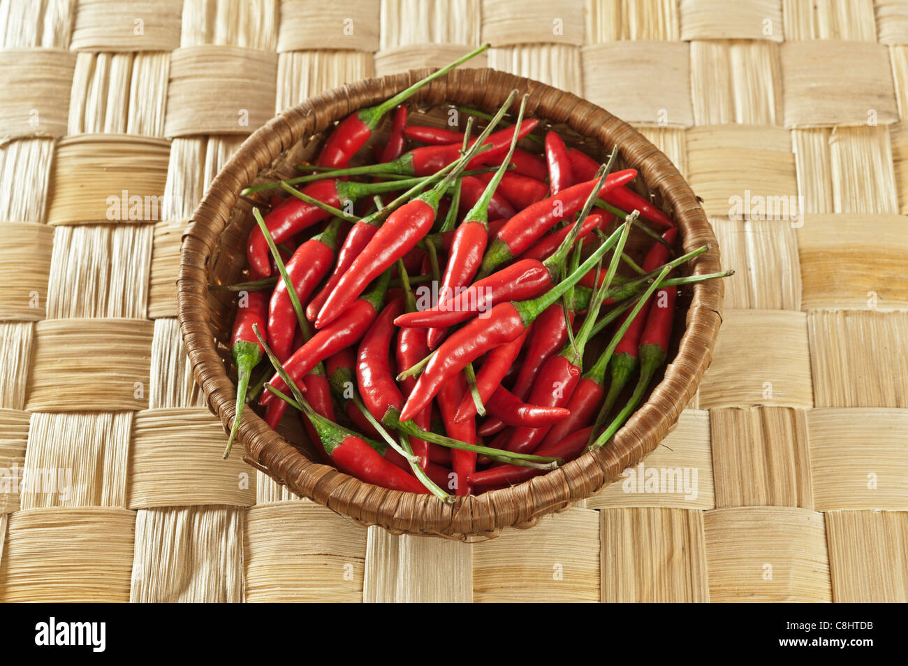 Red chillies on plaited bamboo leaf Stock Photo
