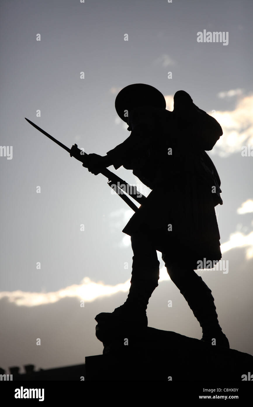 Town of Dingwall, Scotland. Silhouetted view of the kilted soldier WW1 and WWII war memorial on Dingwall’s High Street. Stock Photo