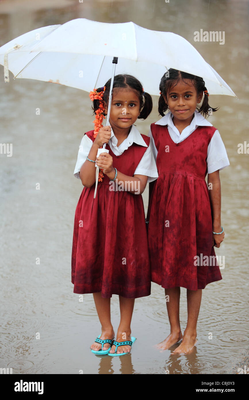 School children under the rain with umbrella Andhra Pradesh South India Stock Photo