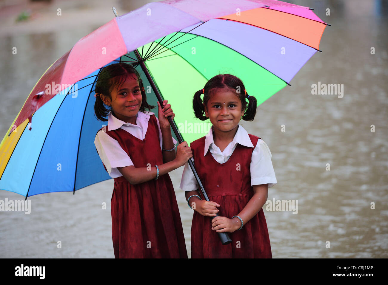 School children under the rain with umbrella Andhra Pradesh South India Stock Photo