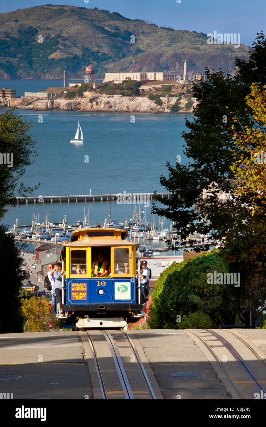 Cable car running up Hyde Street in San Francisco with Alcatraz beyond