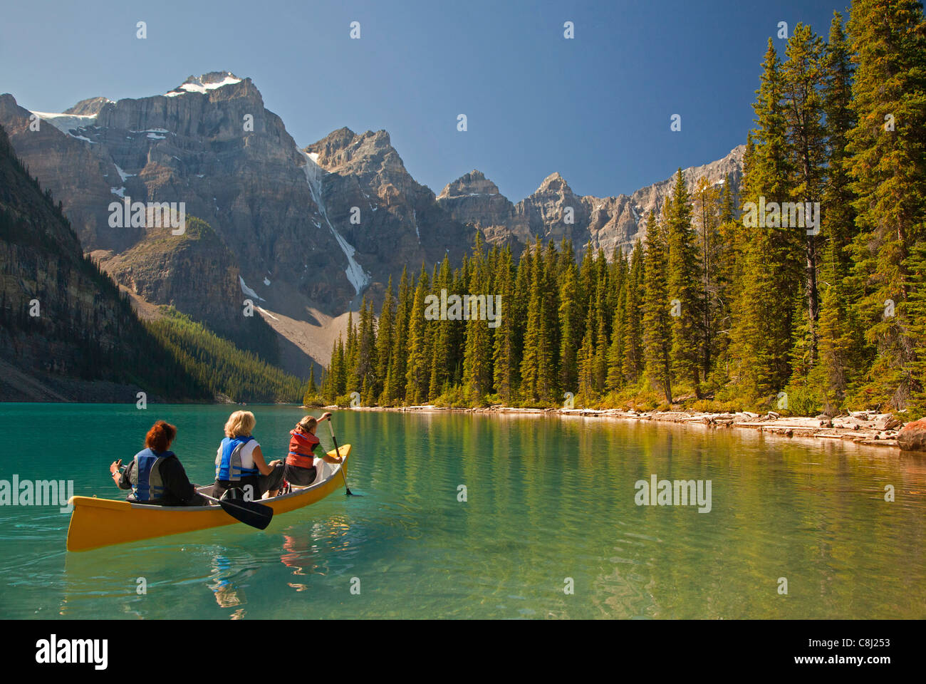 Three women canoeing on Moraine Lake, Banff National Park, Alberta, Canada Stock Photo