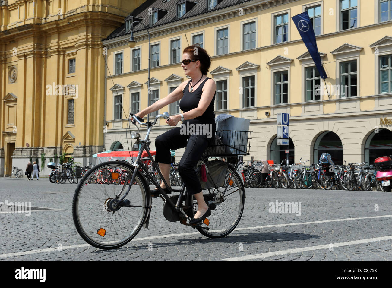 Woman riding bicycle Munich Bavaria Germany Munchen Deutschland Stock