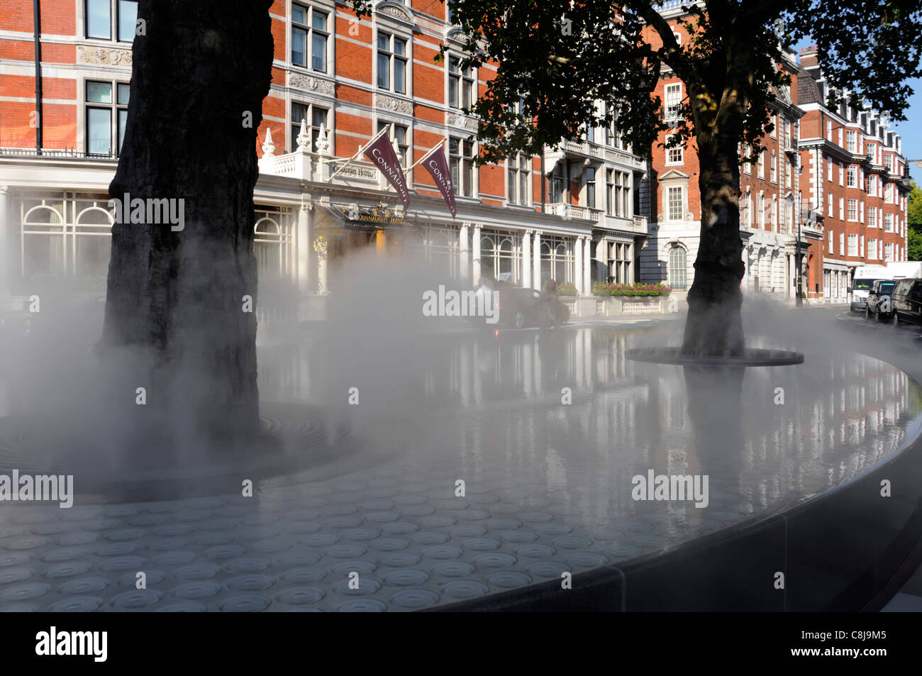 London street scene steam mist vapour cloud on 'Silence’ raised water feature & tree grills by Tadao Ando in Carlos Place Mayfair London West End UK Stock Photo