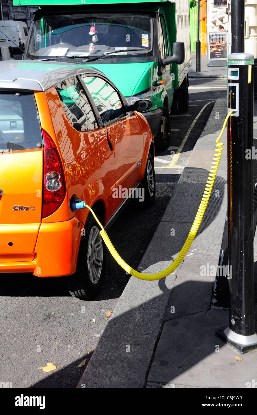 Electric car charging station cable hooked up to recharging bollard London UK Stock Photo