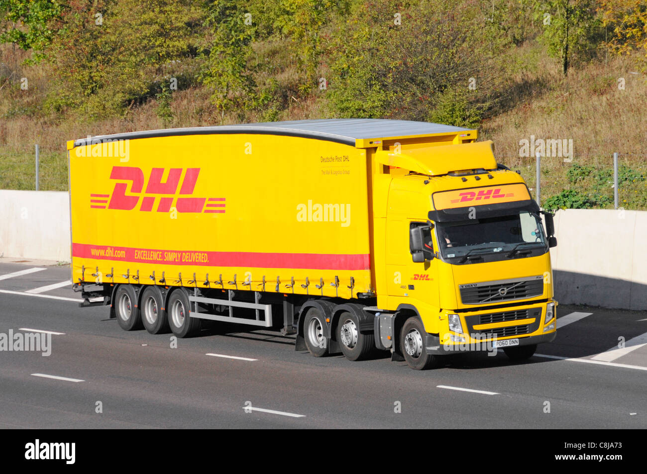 DHL Deutsche Post side & front view Volvo hgv lorry truck & soft sided sliding curtain articulated delivery trailer business brand & logo UK motorway Stock Photo