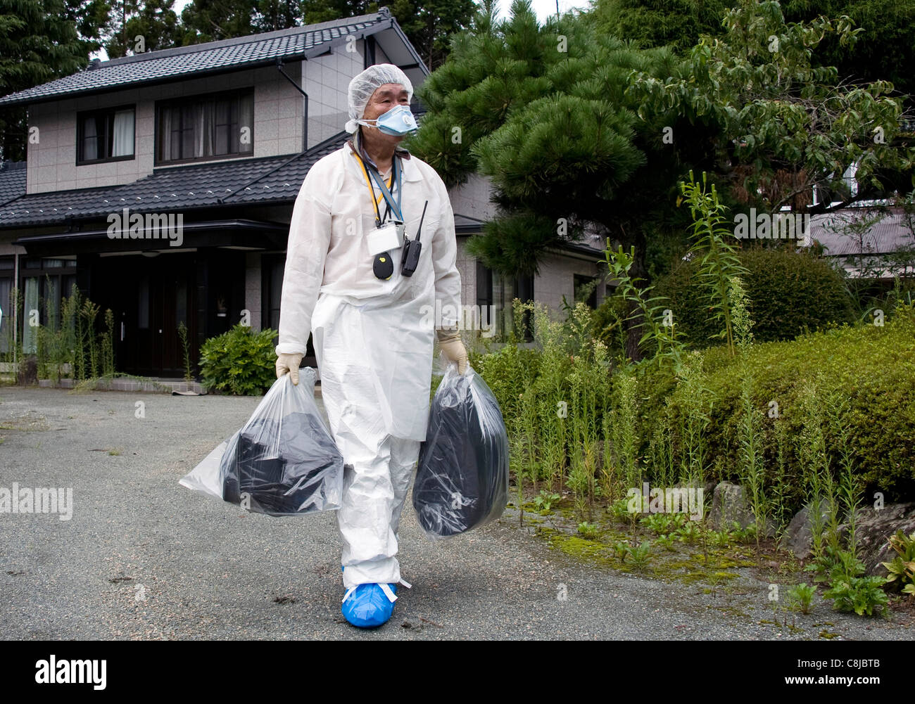 Tokushige Kowata leaves home near the nuclear power plant with for what he believes will be the last time in Okuma, Fukushima Stock Photo