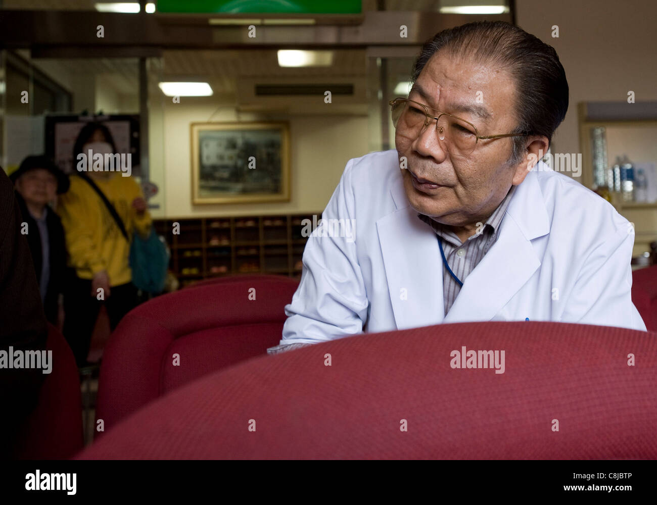 Dr. Kyohei Takahashi talks inside the waiting room of his clinic in Minamisoma, Fukushima Prefecture, Japan Stock Photo