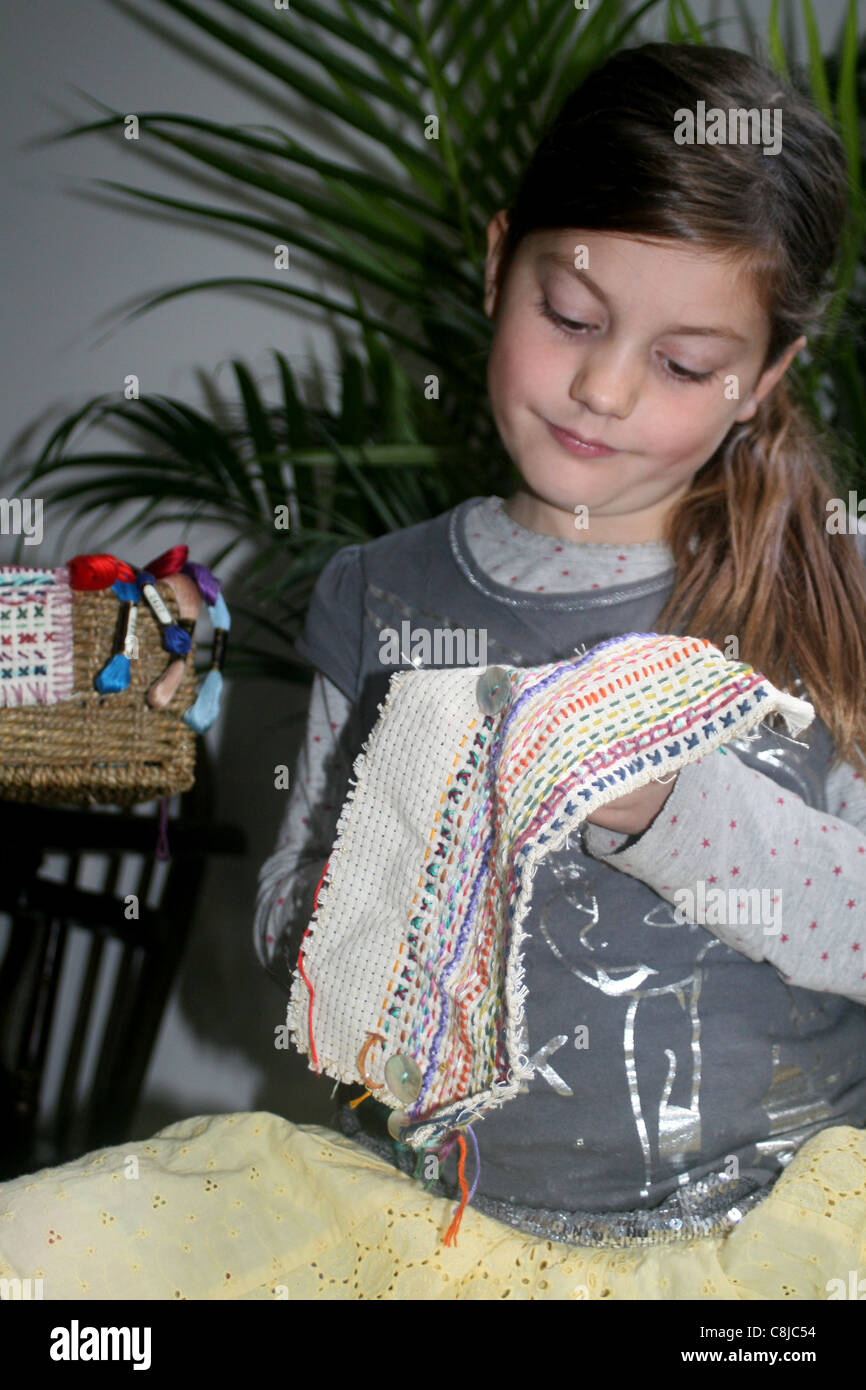 Young girl sewing on aida panel , UK , England Stock Photo