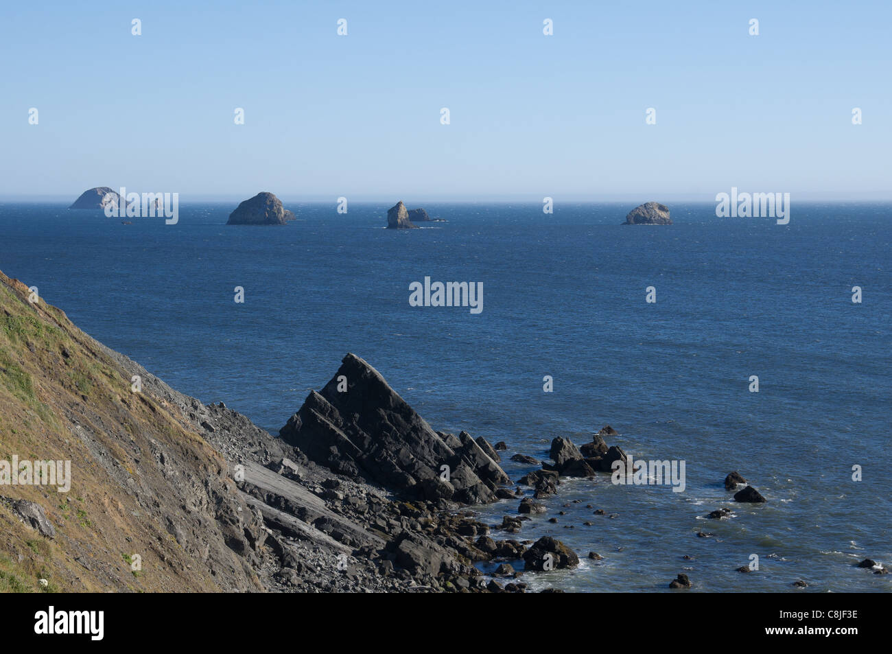 Off Shore Rocks Offshore rock formations rise from the ocean with fog bank in the ...