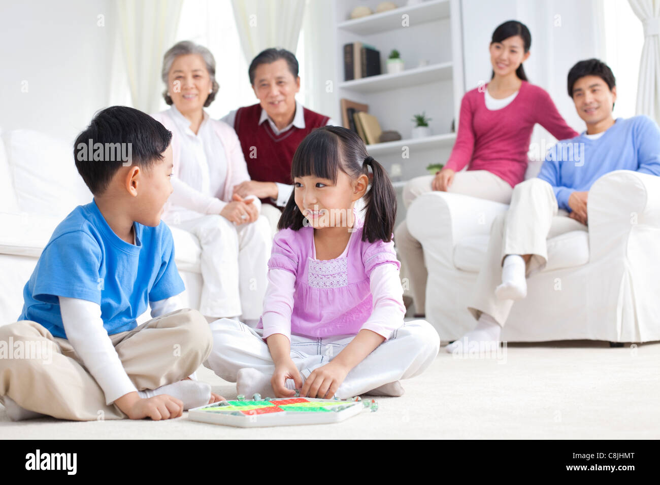 Chinese children playing with toys on the floor with grandparents and