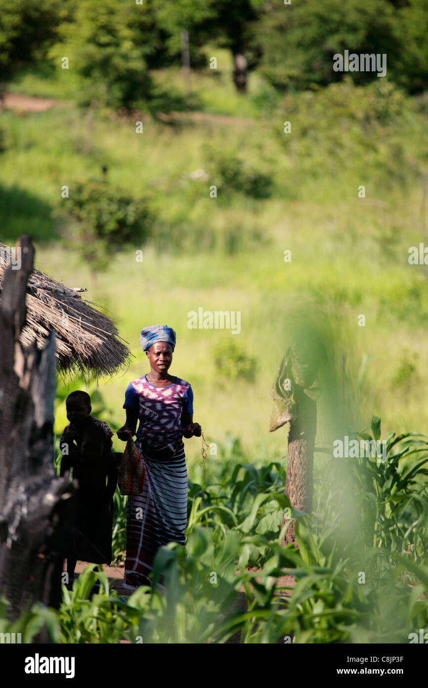 Woman outside her home in lush, tropical Central Mozambique Stock Photo