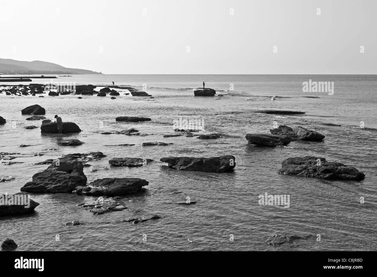 The Mediterranean in Livorno with fishermen between the rocks Stock Photo