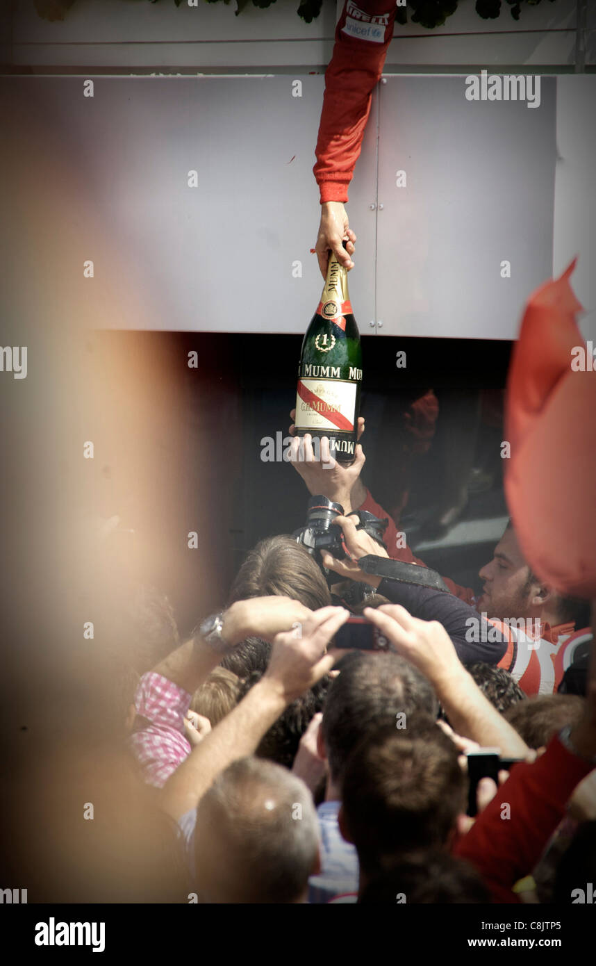 Fernando Alonso passes the winning champagne to team mates after winning the British Formula 1 Grand Prix at Silverstone Stock Photo