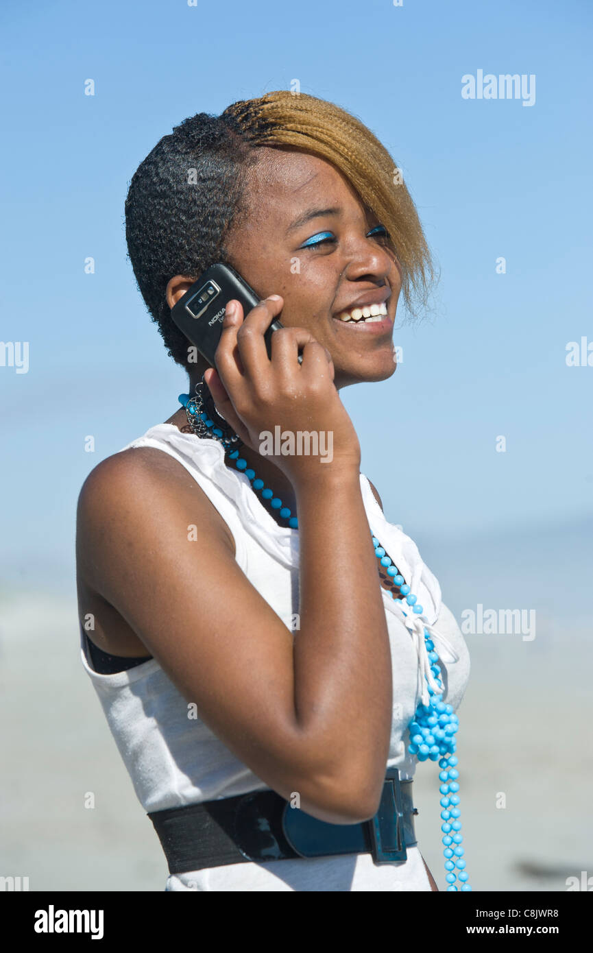 Teenager makes a phone call with her mobile phone Grotto Beach Western Cape South Africa Stock Photo