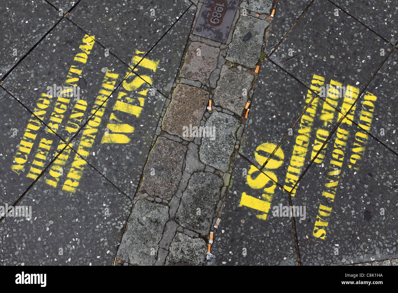 Political graffiti by the outline of what was once the Berlin Wall in Berlin, Germany. Stock Photo