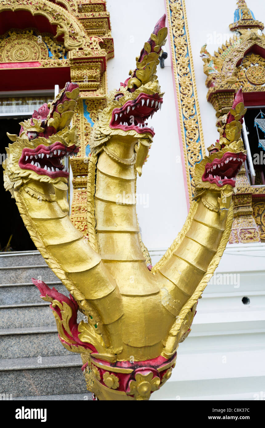 Fierce looking 3 headed gold serpents sculpture on staircase of Thai temple at Wat Doi Saket in northern Thailand Stock Photo