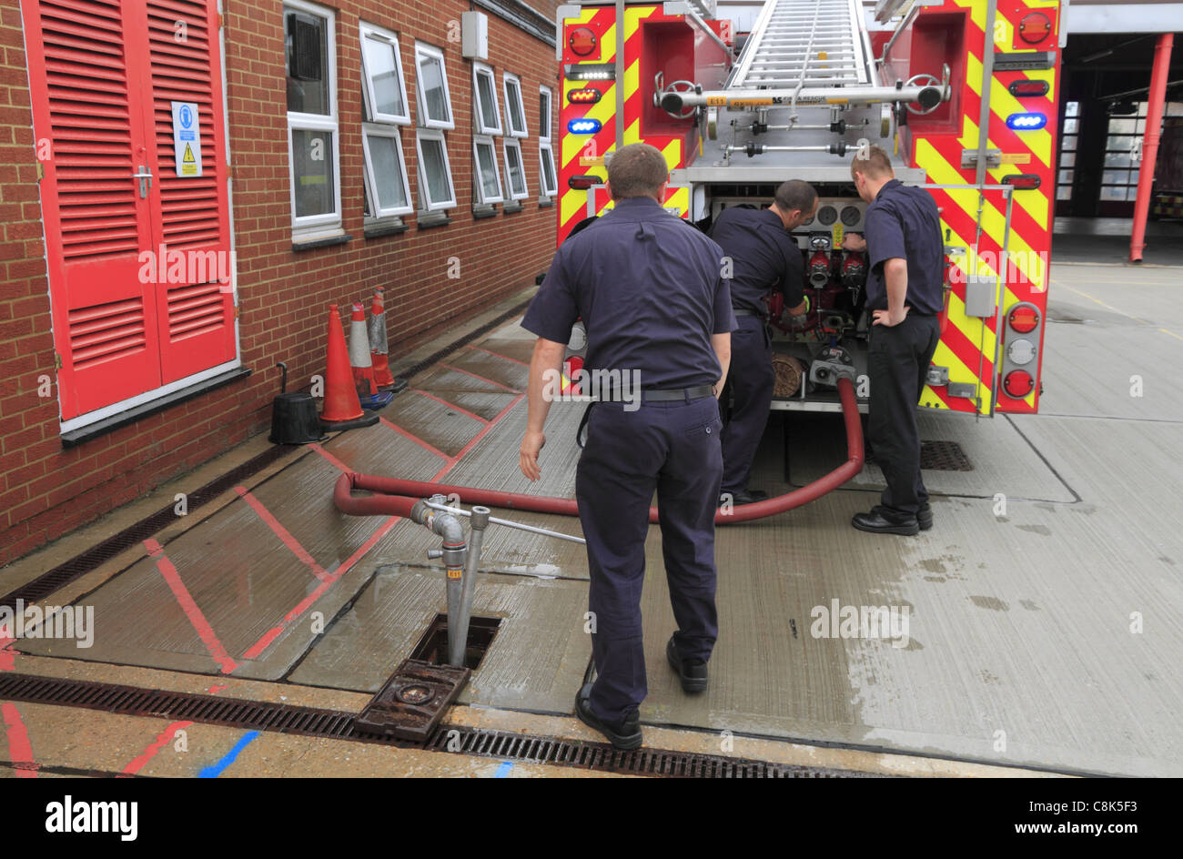Firemen prepare to top up the water in a fire engine at Eastbourne Fire Station, East Sussex, England. Stock Photo