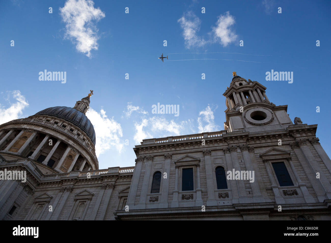 Plane flies over St Paul's Cathedral leaving a vapour trail, probably on its approach to London City airport Stock Photo