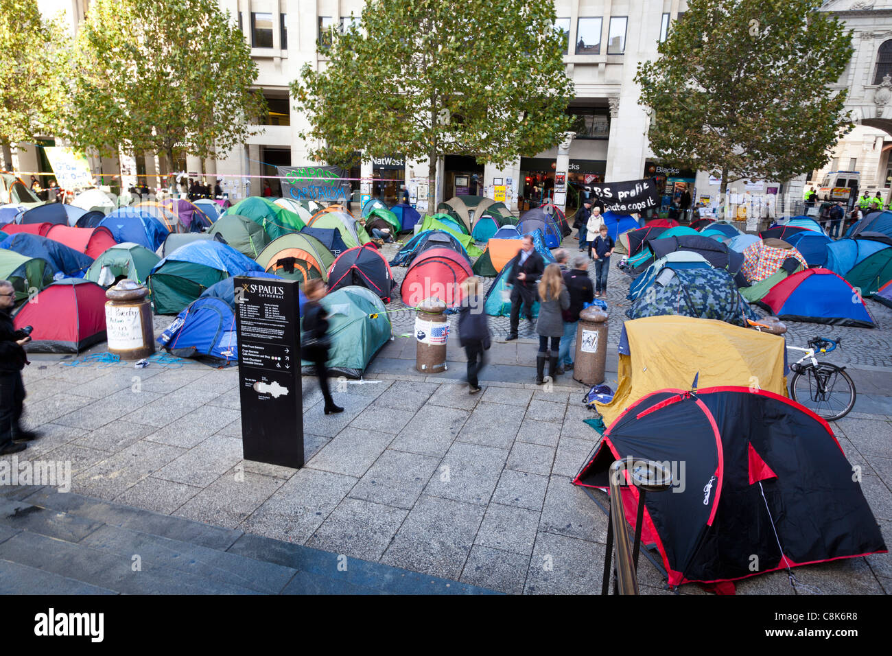 People pass between anti-capitalist protesters' tents outside St Paul's Cathedral, London, October, 2011. Stock Photo