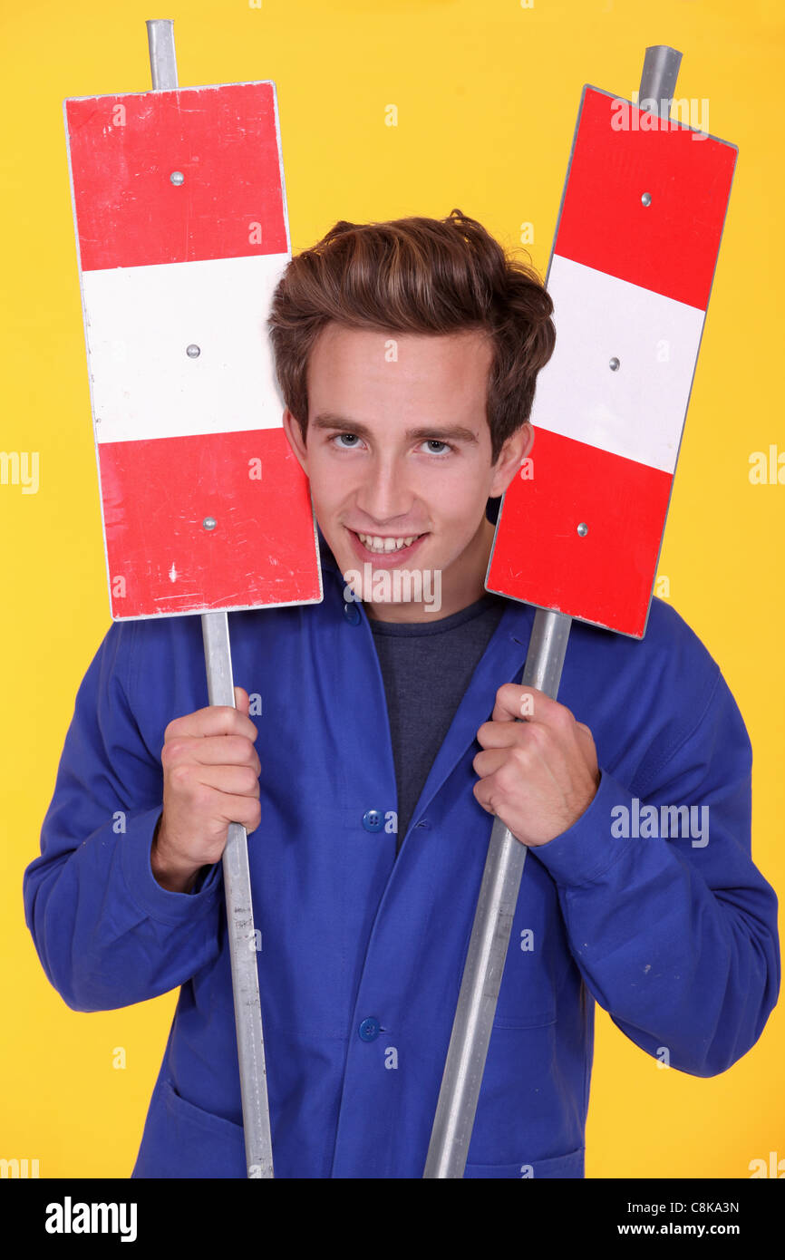 Man holding two metal road signs Stock Photo