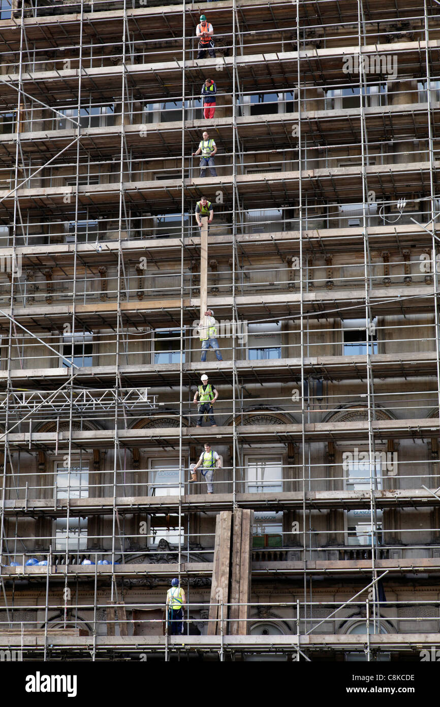 Workers erecting scaffold on a building during repairs, Glasgow, Scotland, UK Stock Photo