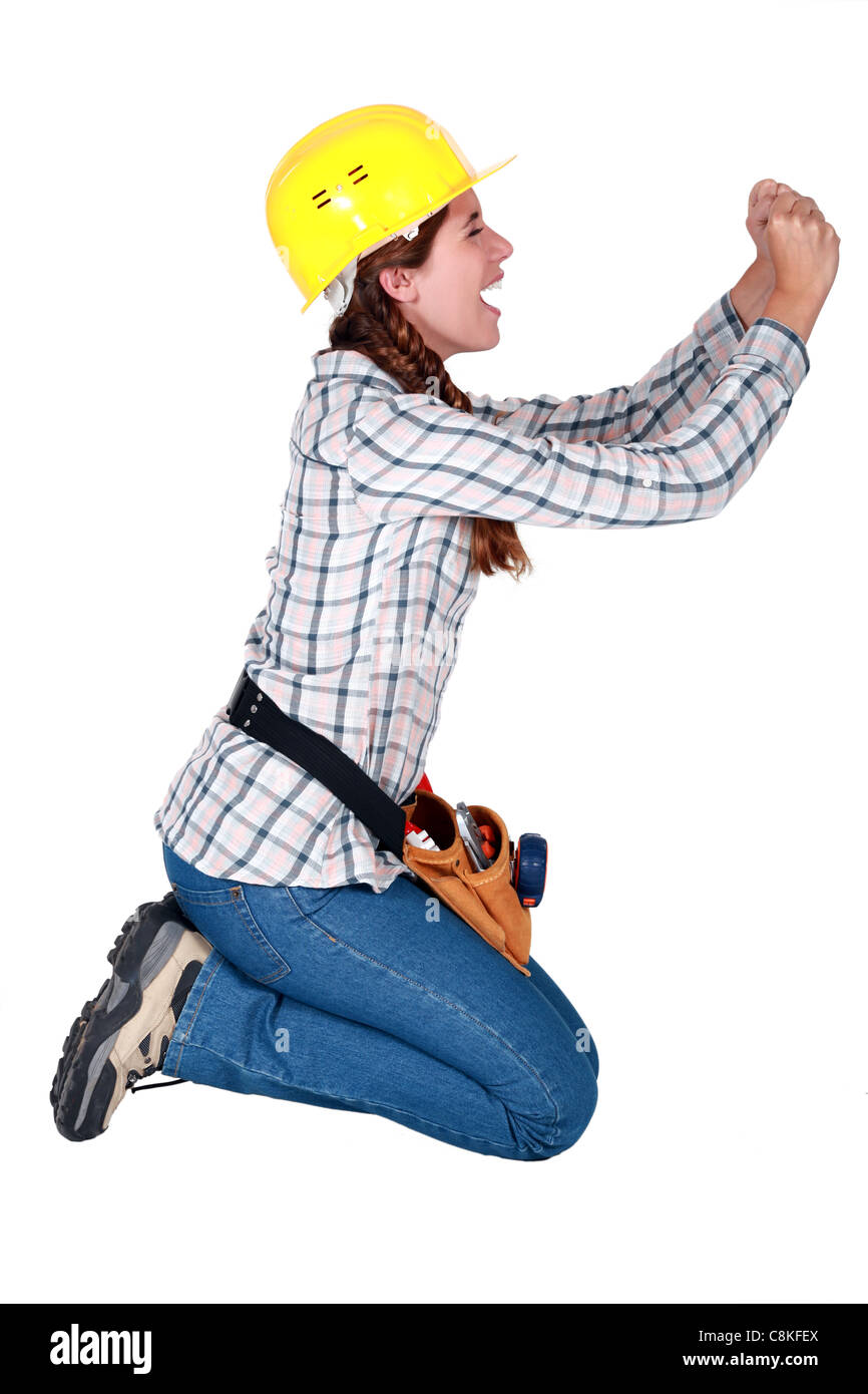 Construction worker on her knees begging Stock Photo