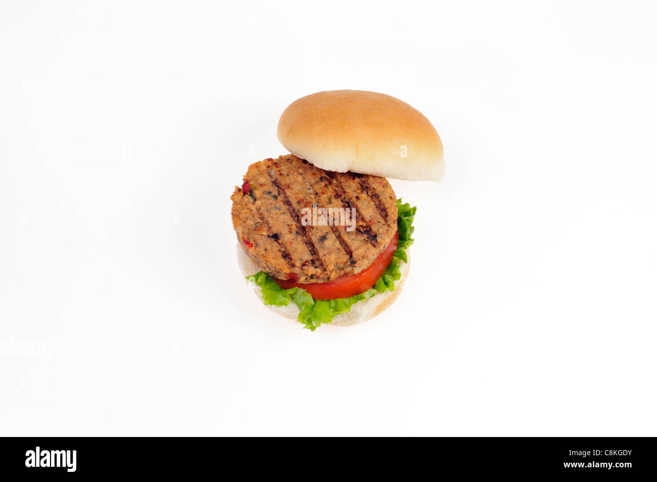 Open grilled veggie burger with lettuce and tomato in bread roll on white background cutout. Stock Photo