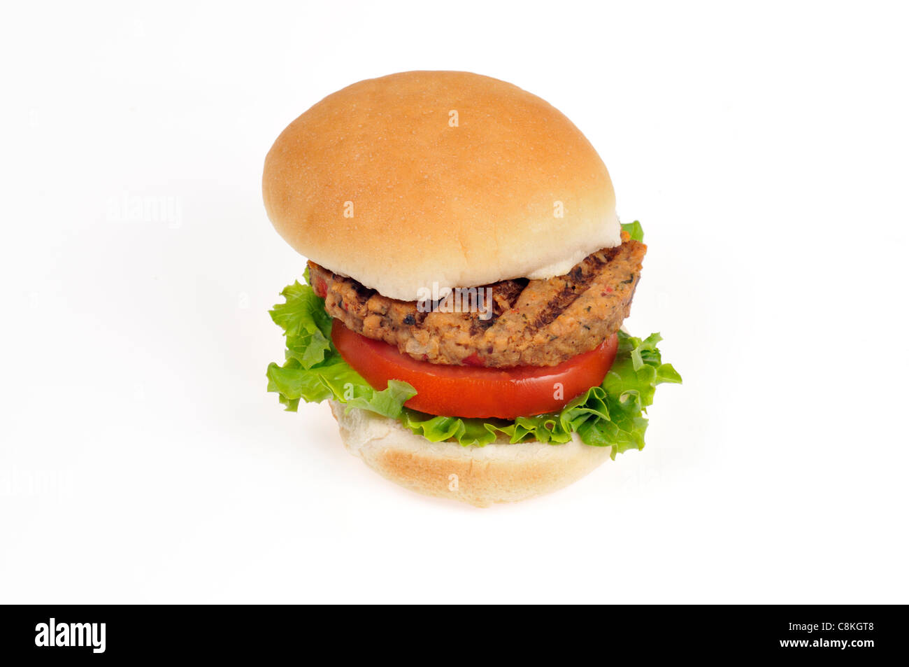Grilled veggie burger with lettuce and tomato in bread roll on white background cutout. Stock Photo