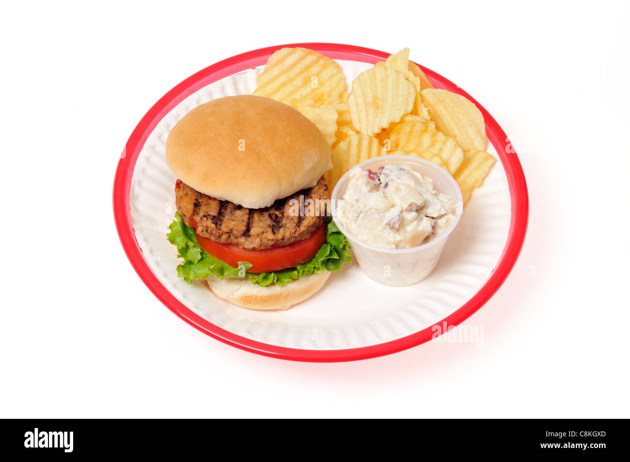Grilled veggie burger with lettuce and tomato in bread roll in a red retro plastic plate basket on white background, cutout. Stock Photo