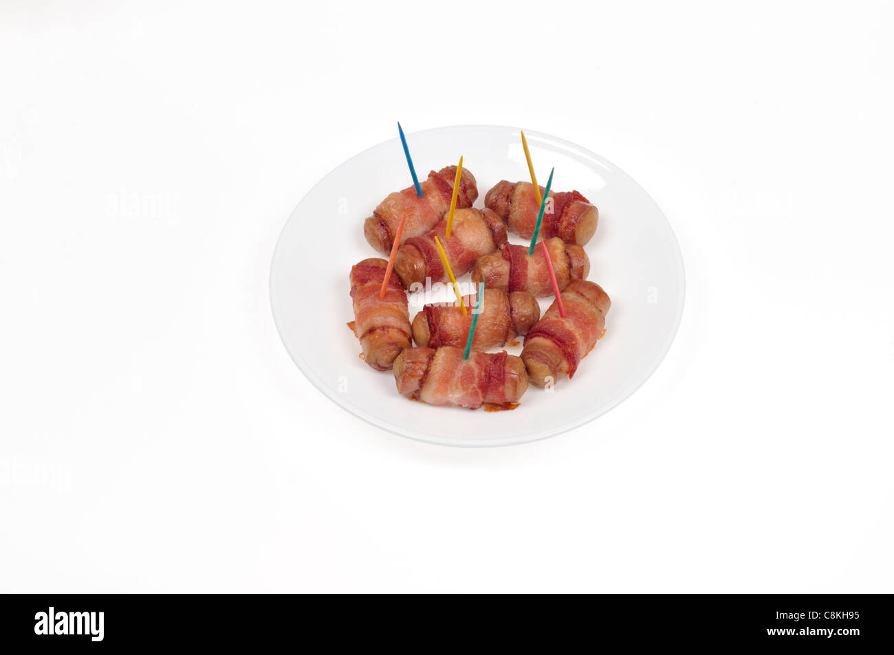 Pigs in blanket  hors d'ouevres on white plate on white background cutout. Stock Photo
