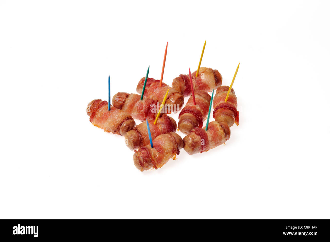 Pigs in blanket, sausages wrapped in bacon, appetizers with multi coloured toothpicks on white background cutout Stock Photo