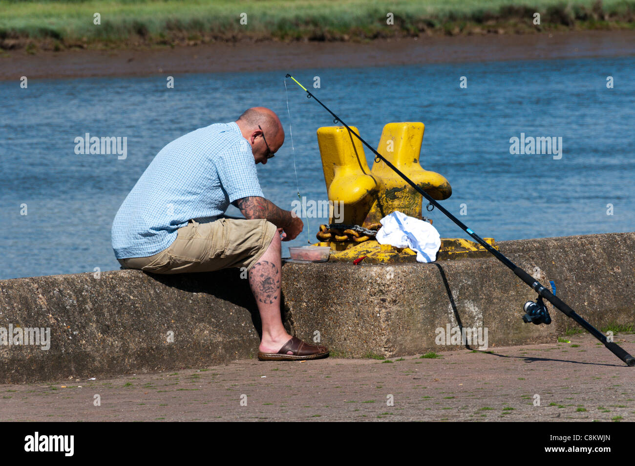 A man fishing on the South Quay, King's Lynn, Norfolk, England Stock Photo