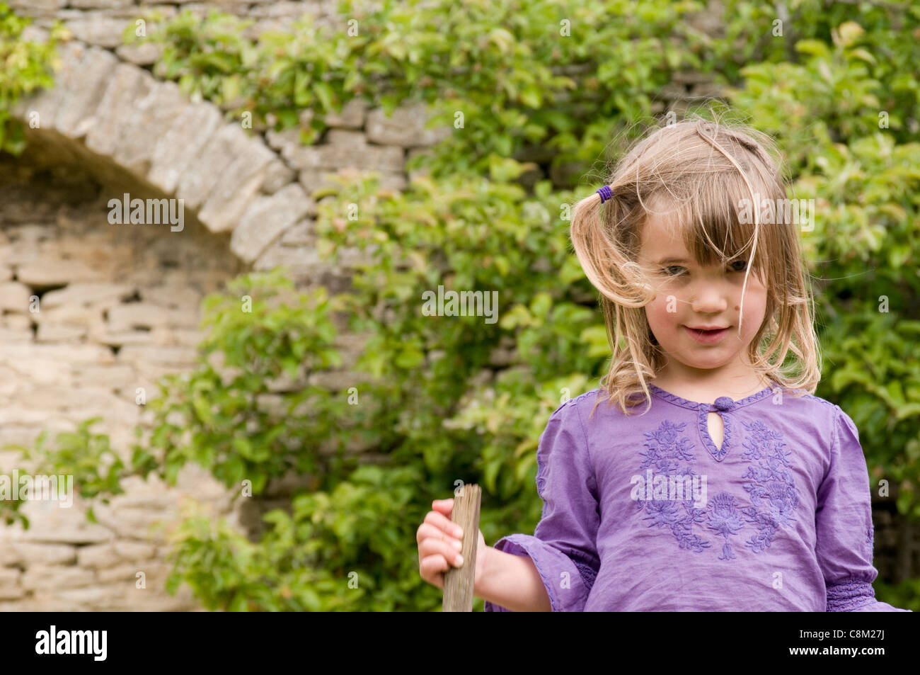 Portrait Of A Little Girl With Medium Length Blonde Hair Standing