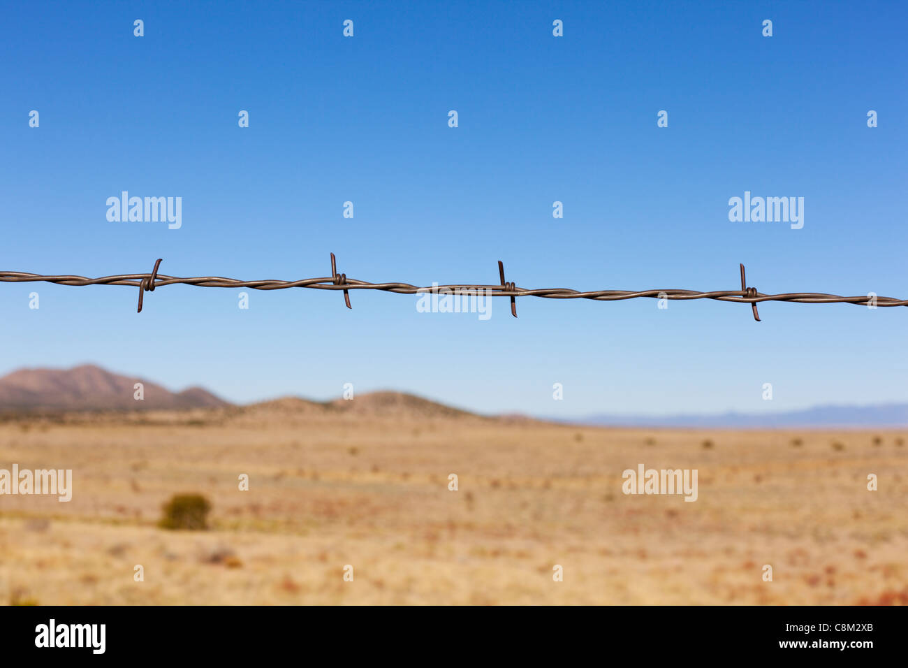 Barbed wire fence detail in a rural New Mexican landscape. Stock Photo