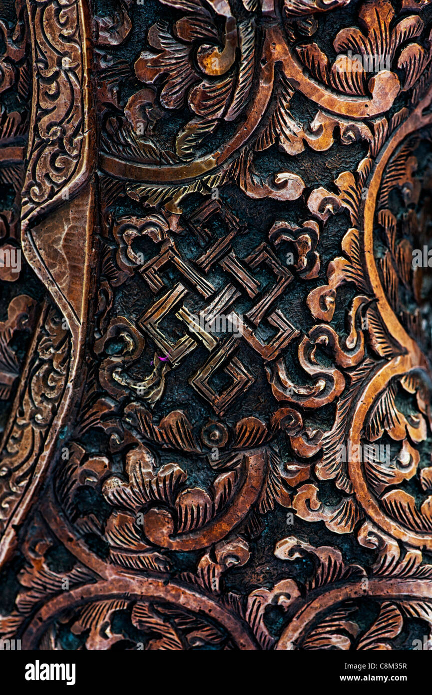 Bronze Tibetan Medicine Buddha robe detail showing Endless knot. A buddhist motif Stock Photo