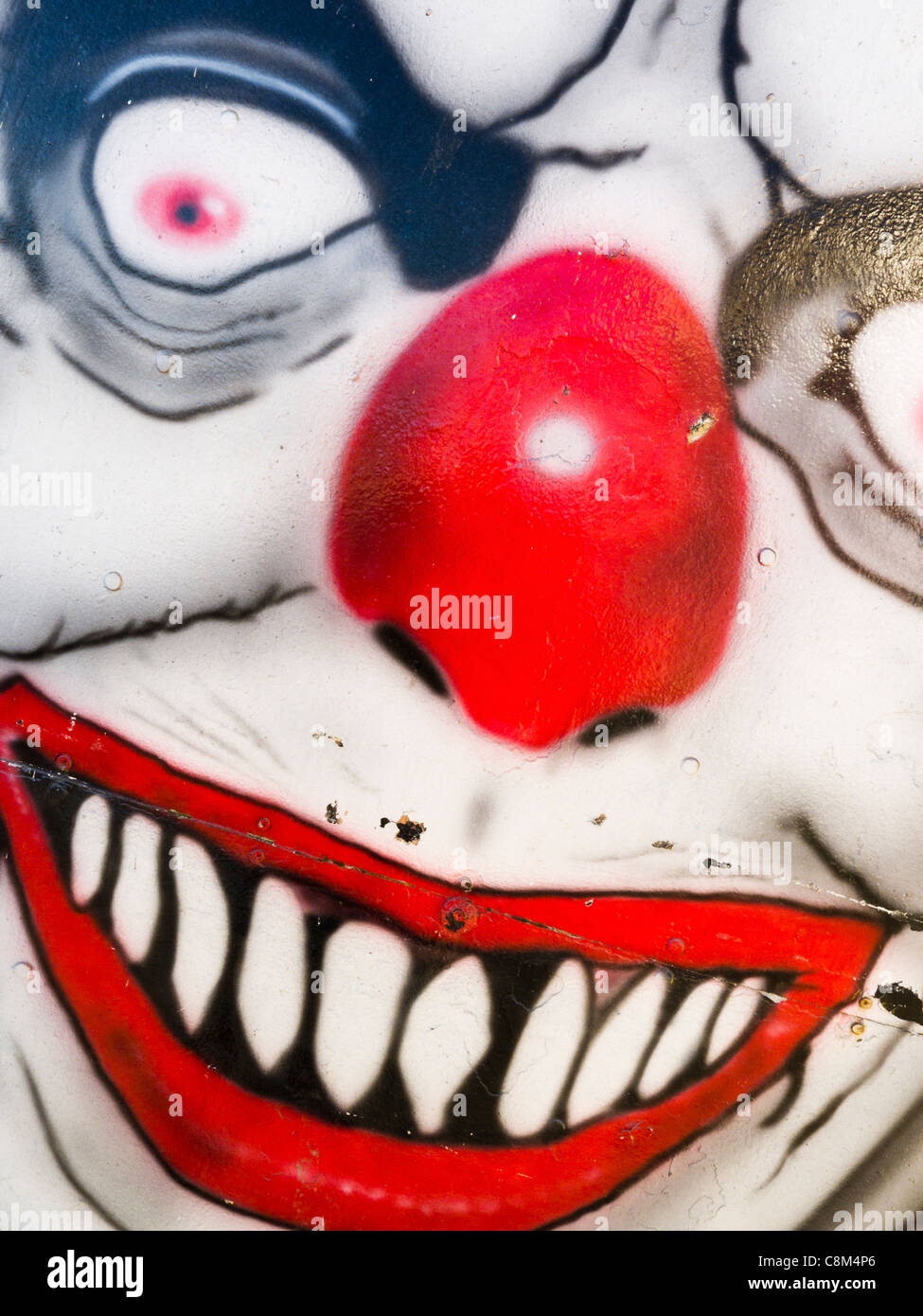 An evil clowns face painted on the housing for a ghost train. Stock Photo