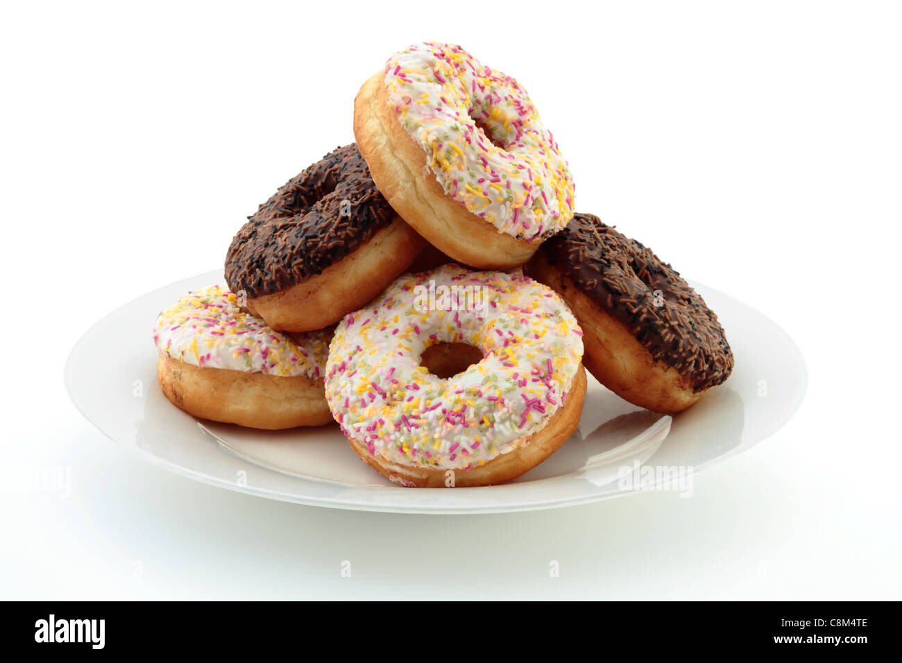 a-pile-of-iced-donuts-or-doughnuts-on-a-plate-isolated-on-a-white-C8M4TE.jpg