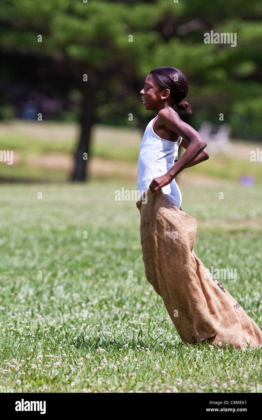 Young black female child in potato sack race. Stock Photo