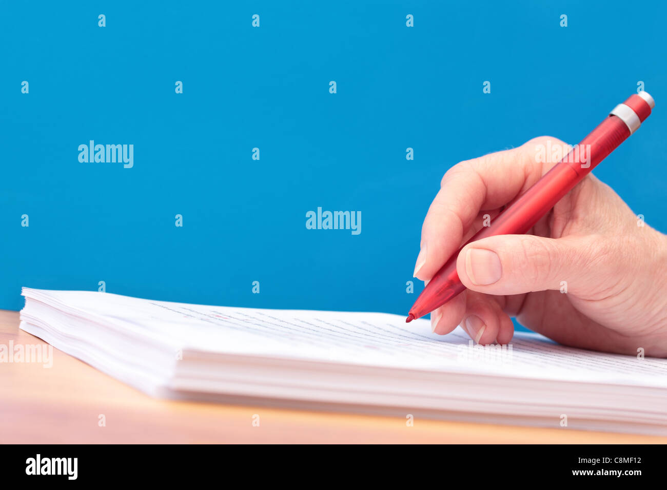Hand with Pen Proofreading a Manuscript any Language Stock Photo