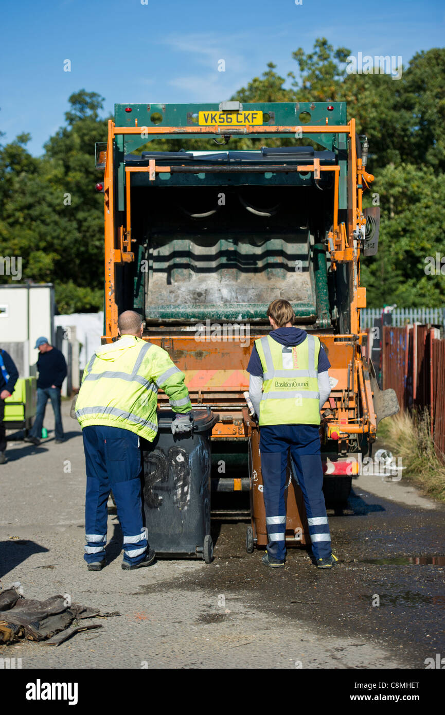 Refuse workers from Basildon Council in Essex working at rear of dust cart  loading and emptying wheely (wheeled) bins into rear Stock Photo - Alamy