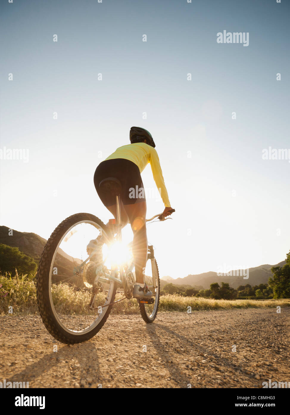 Mixed race woman riding on mountain bike Stock Photo