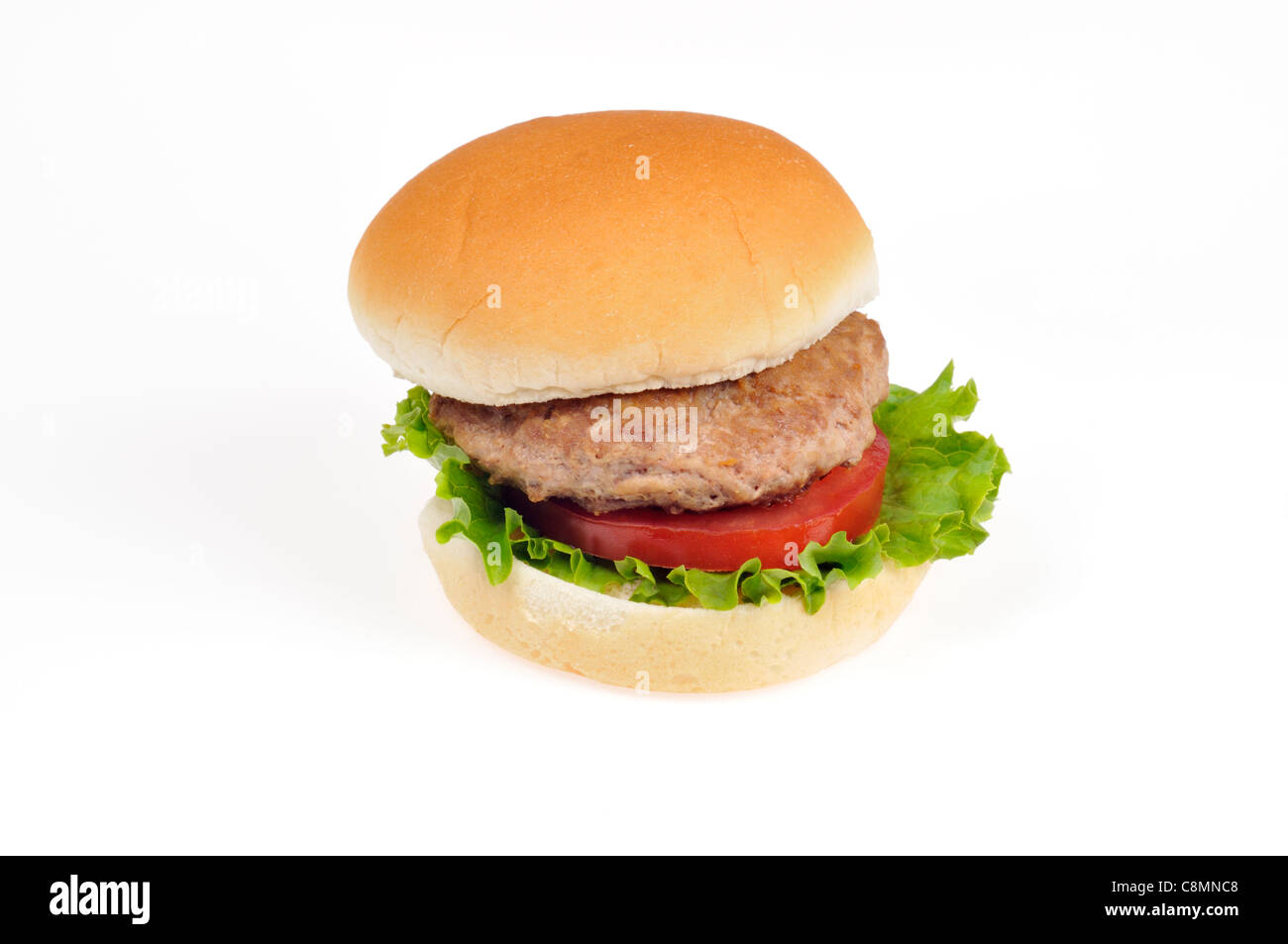 Turkey burger with lettuce and tomato in bread roll on white background cutout. Stock Photo