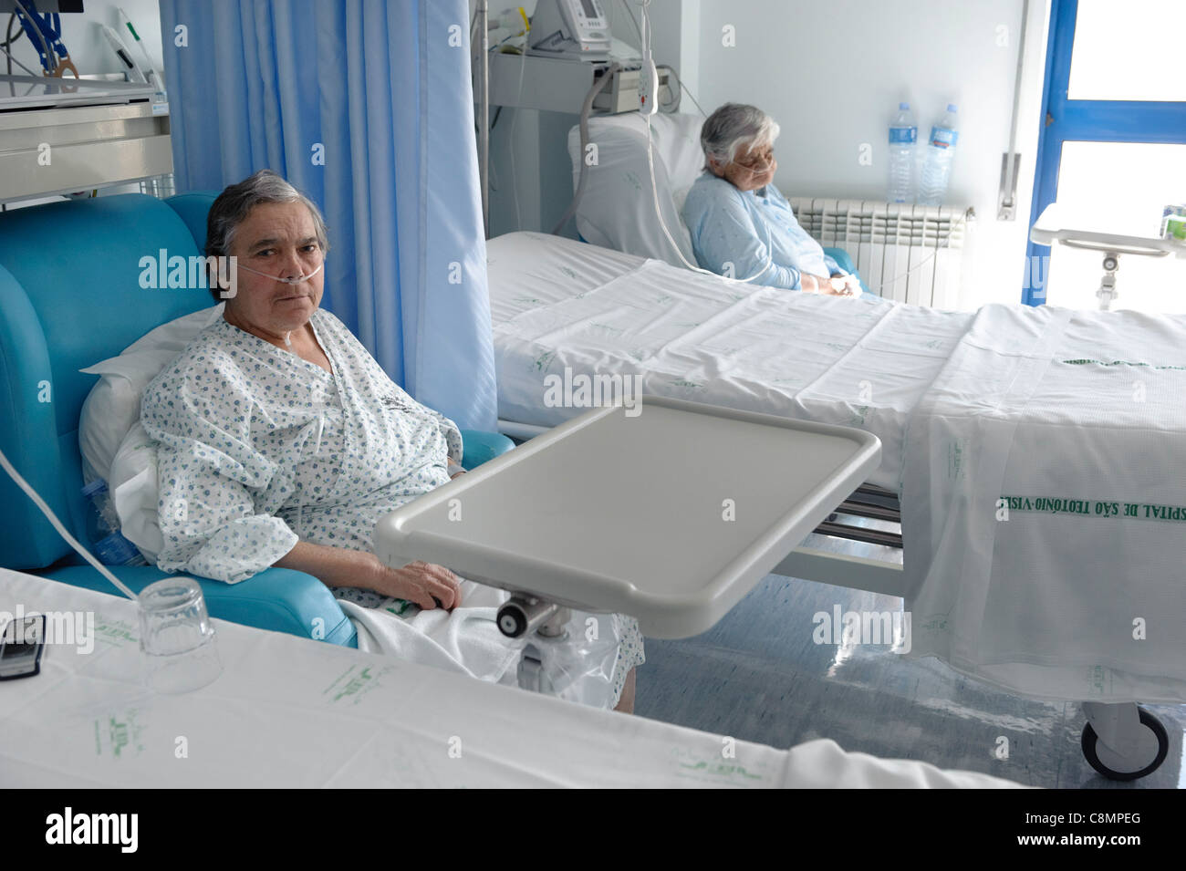 Two elderly women sitting in an hospital ward Stock Photo