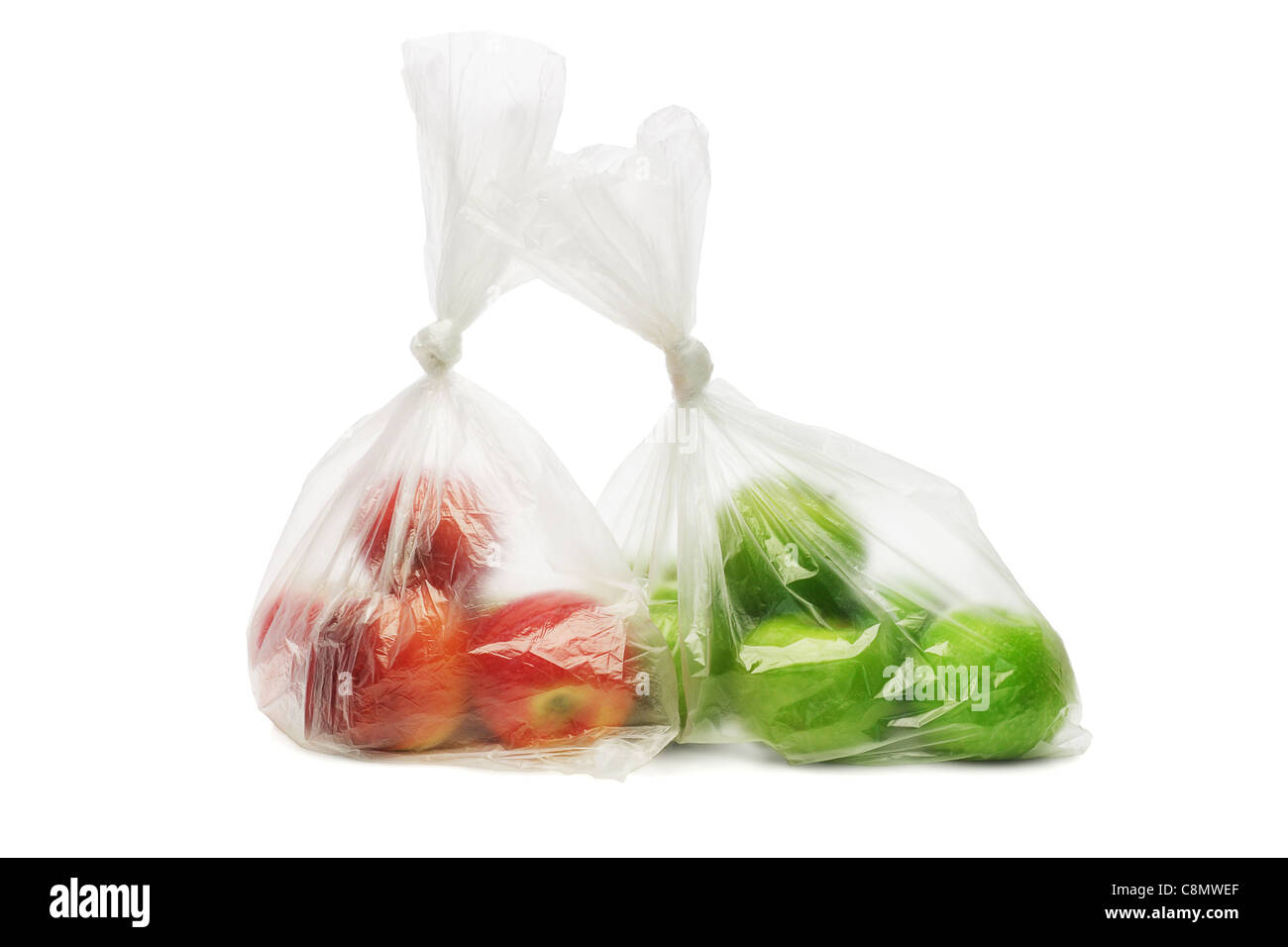 Two plastic bags of red and green apples on white background Stock