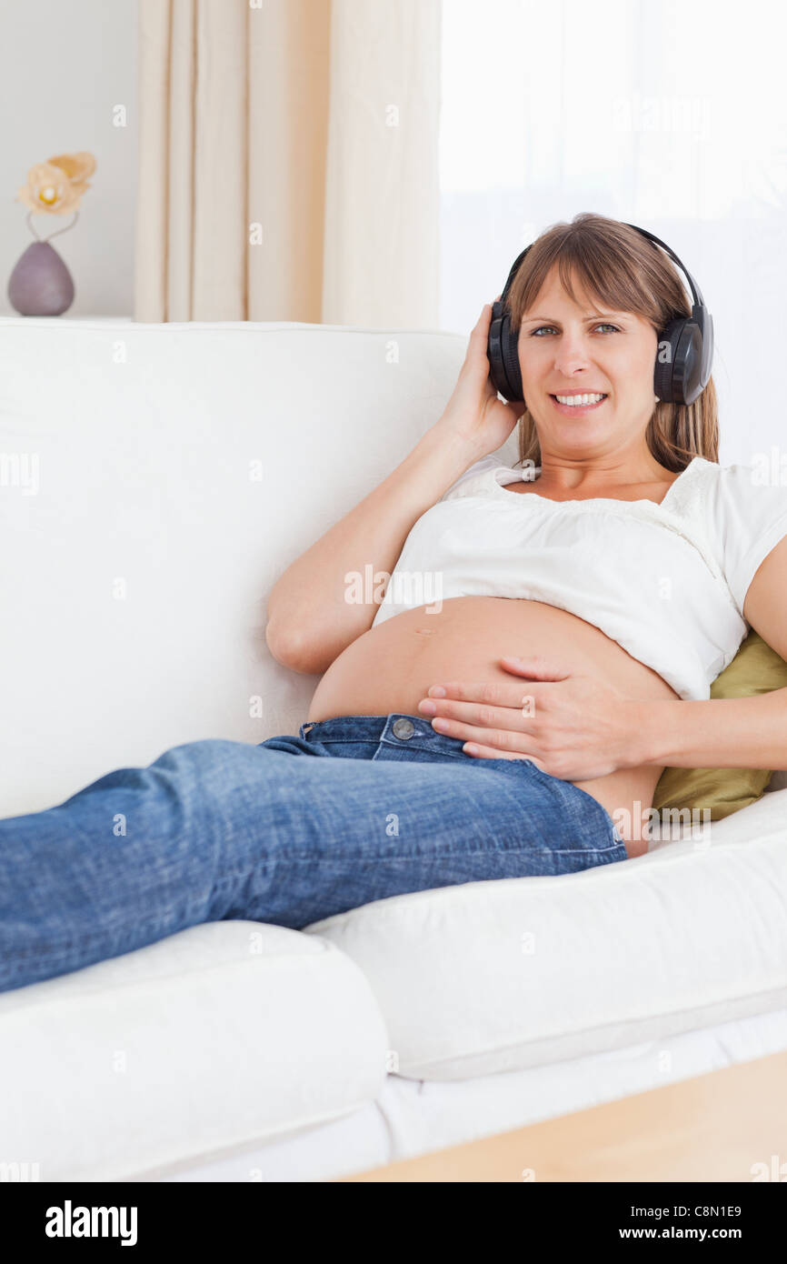 Portrait of a smiling pregnant woman listening to music Stock Photo - Alamy