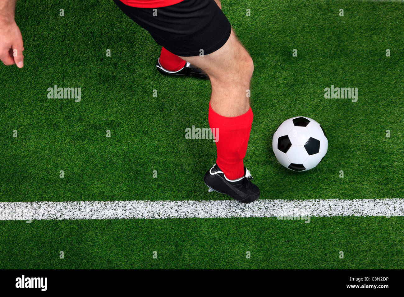 Overhead photo of a football or soccer player dribbling with the ball on the sideline Stock Photo