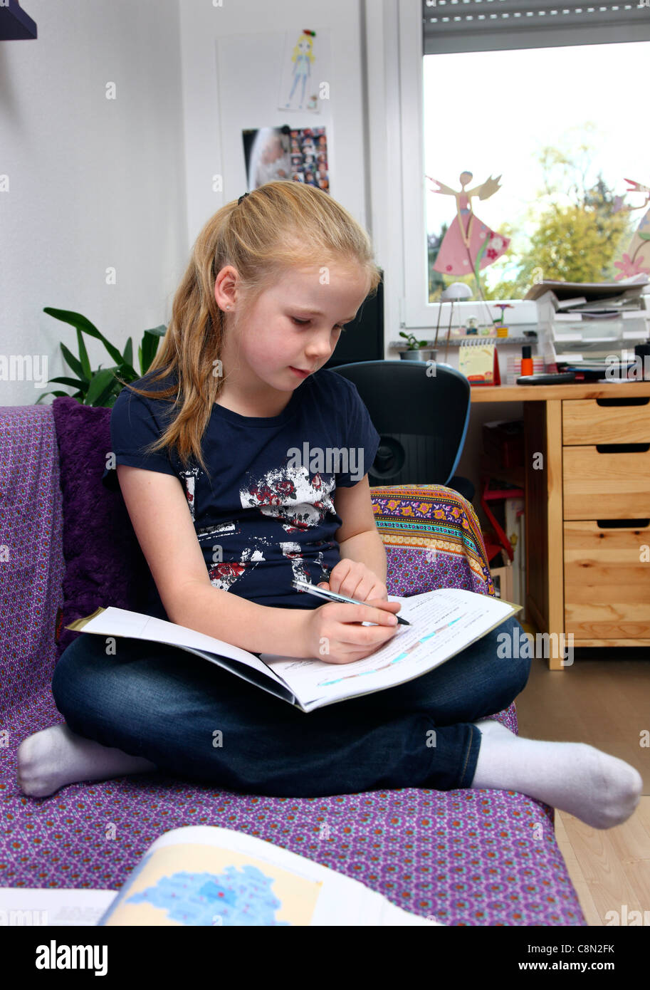 Girl, 10 years old, learning for school, at home in her room, doing homework. Stock Photo