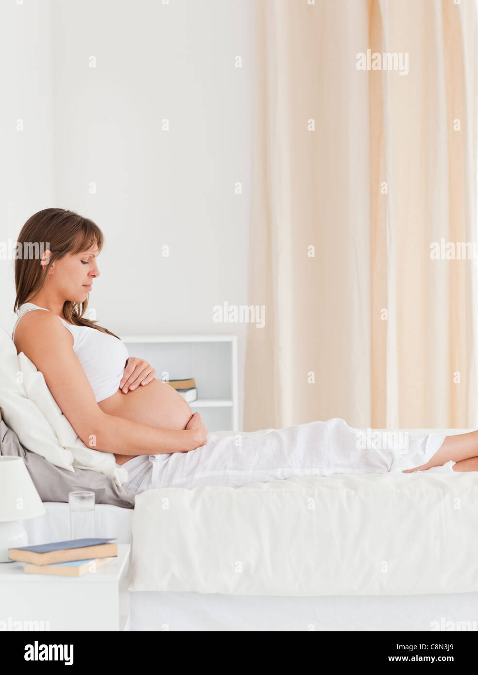 Portrait of a pregnant female lying on a bed Stock Photo Alamy